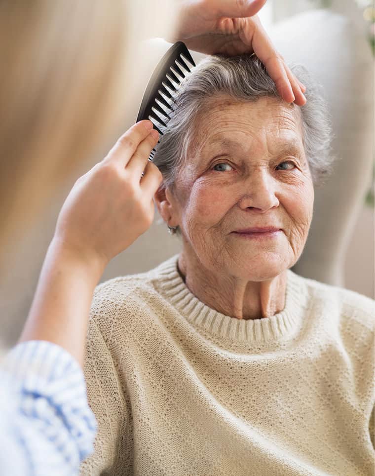 The extra mile: Wellbeing - a hairdresser combing lady's hair